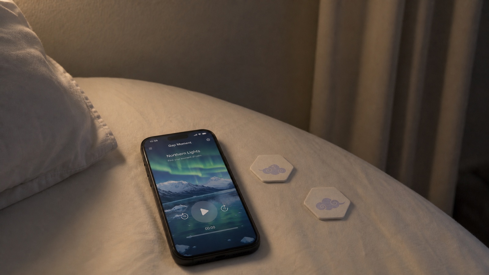 A phone resting on a bed at night, the Gap Moment app glowing